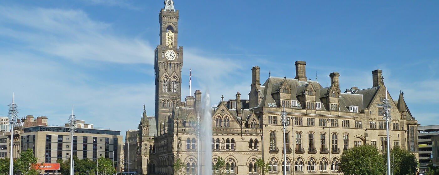 Bradford City Hall and its clock tower seen across the City Park fountains on a clear day