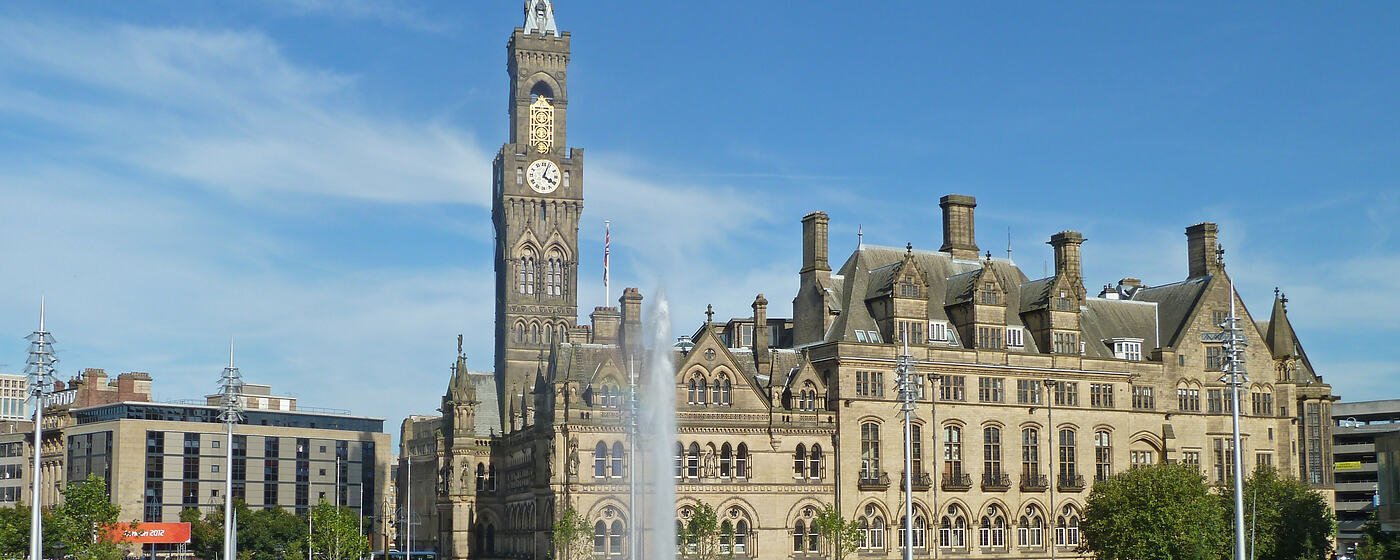 Bradford City Hall and its clock tower seen across the City Park fountains on a clear day
